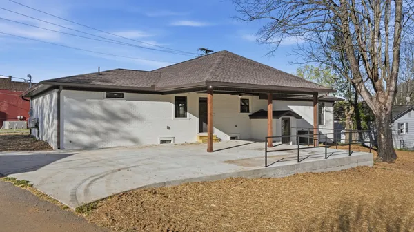 a white house that has a tree in front of it