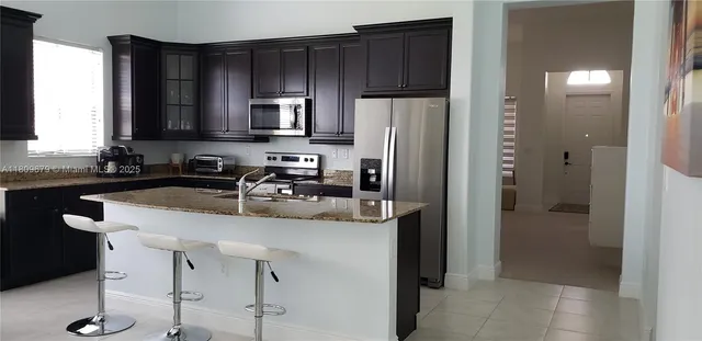 a kitchen with a sink a refrigerator a stove a microwave and island