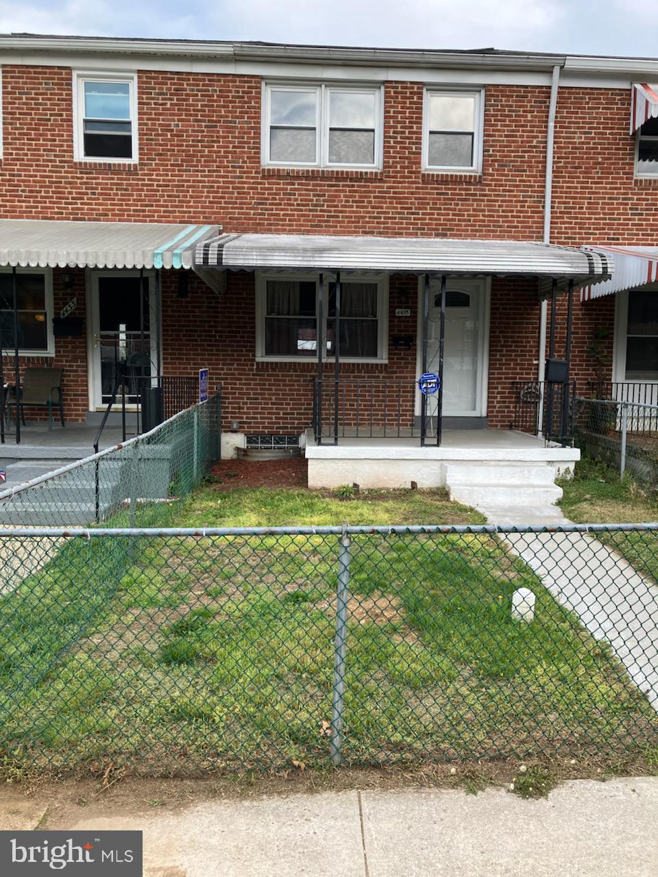front view of a brick house with a yard