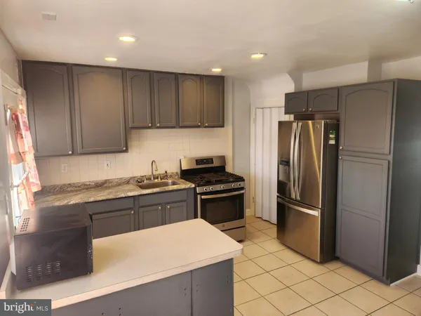 a kitchen with stainless steel appliances granite countertop a refrigerator stove and sink