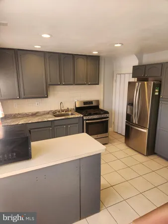 a kitchen with granite countertop a refrigerator and a sink