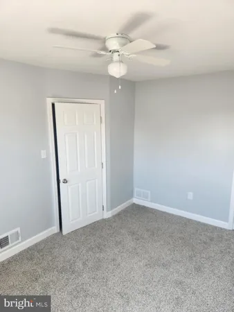 a view of an empty room and a ceiling fan