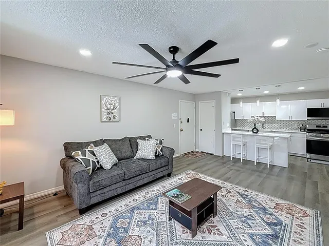 a living room with furniture and a view of kitchen