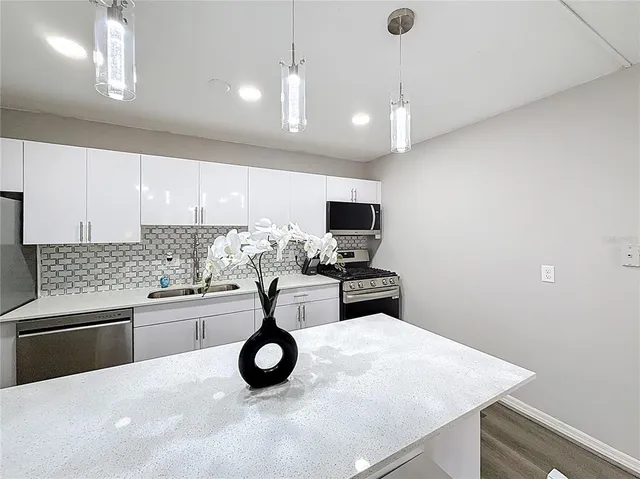 a kitchen with a sink a stove and chairs