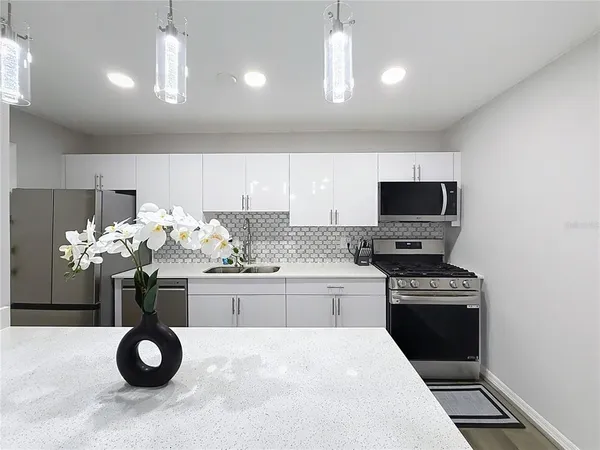 a kitchen with a microwave a stove and cabinets
