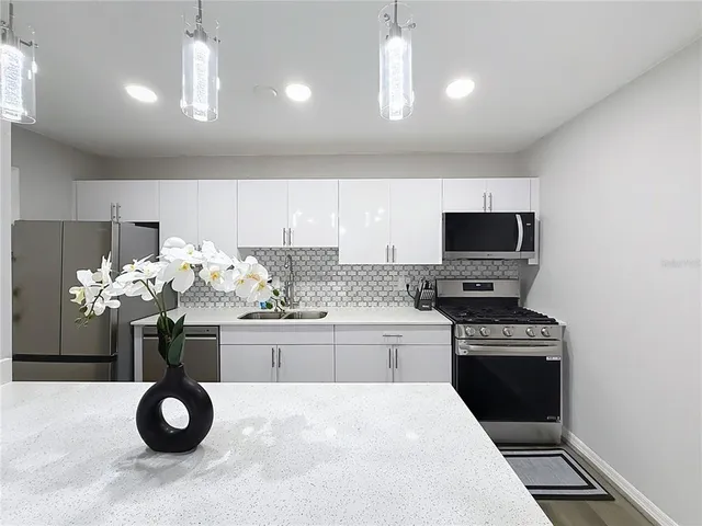 a kitchen with a microwave a stove and cabinets