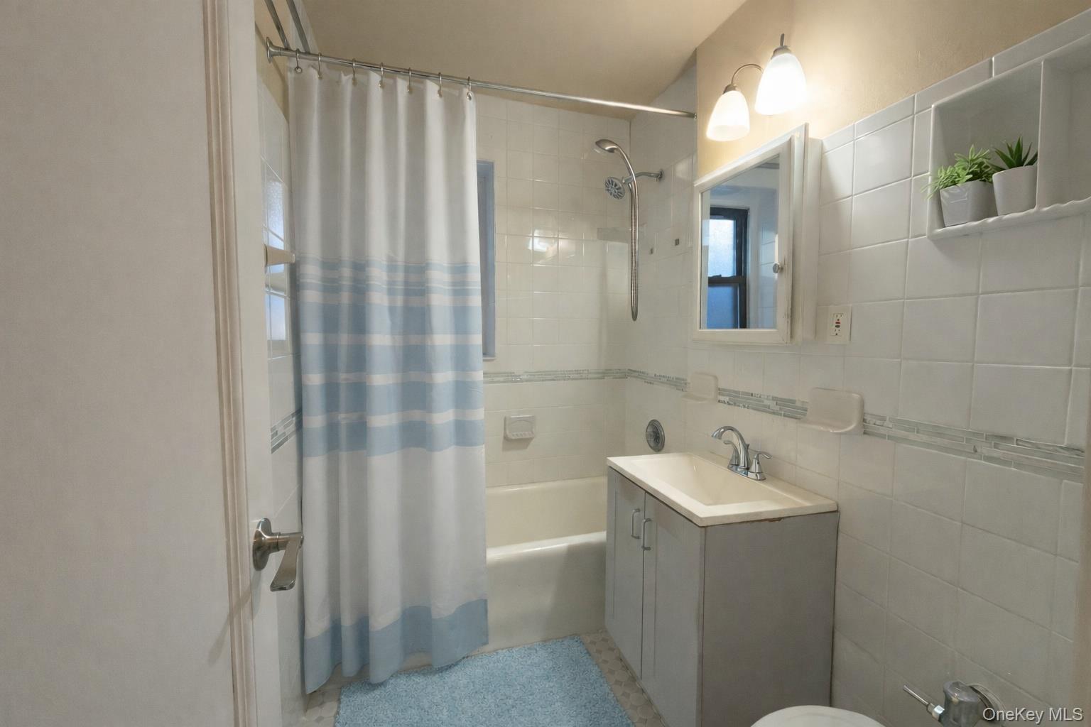 42 Barker Avenue, Unit 2B White Plains, NY 10601 - Photo 8 of 13 Bathroom featuring shower / bath combo, vanity, and tile walls