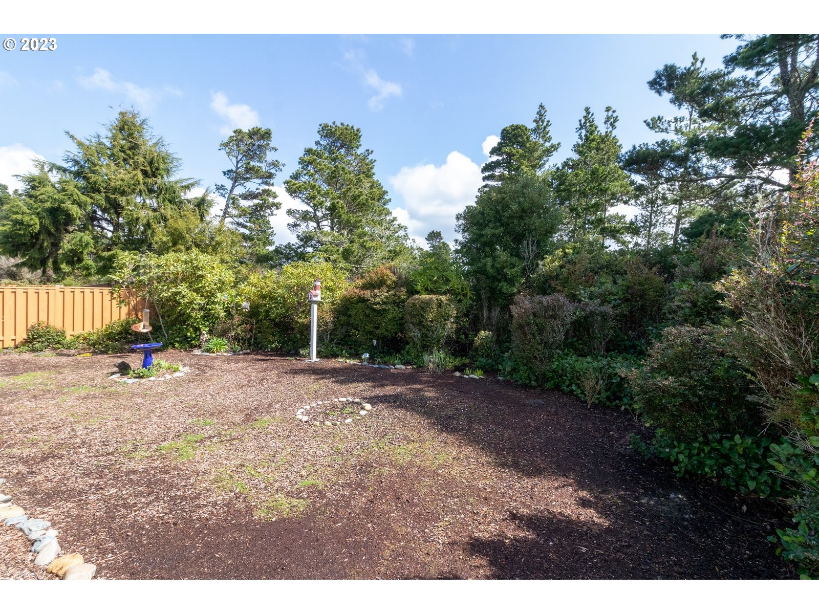 18 Mariners Lane Florence, OR 97439 - Photo 24 of 28 a view of a yard with potted plants and large trees