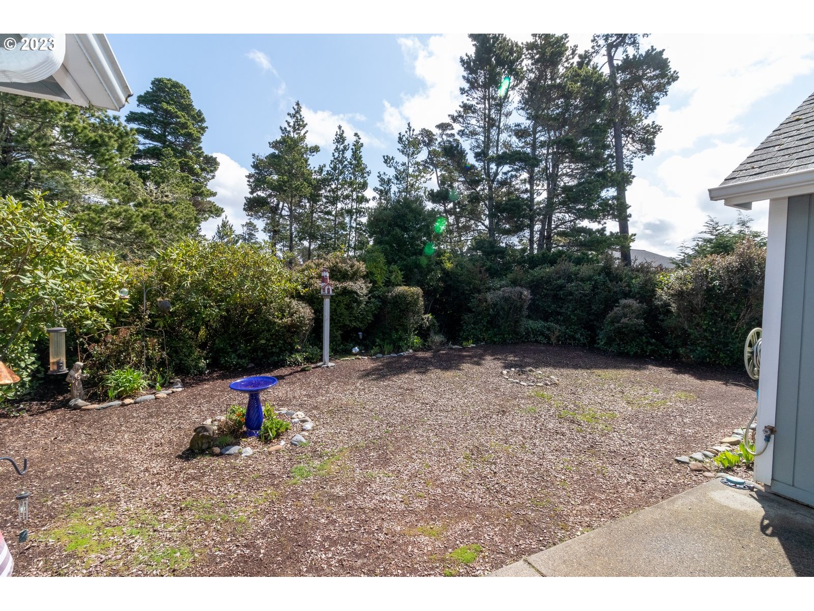18 Mariners Lane Florence, OR 97439 - Photo 25 of 28 a backyard of a house with fire pit and trees
