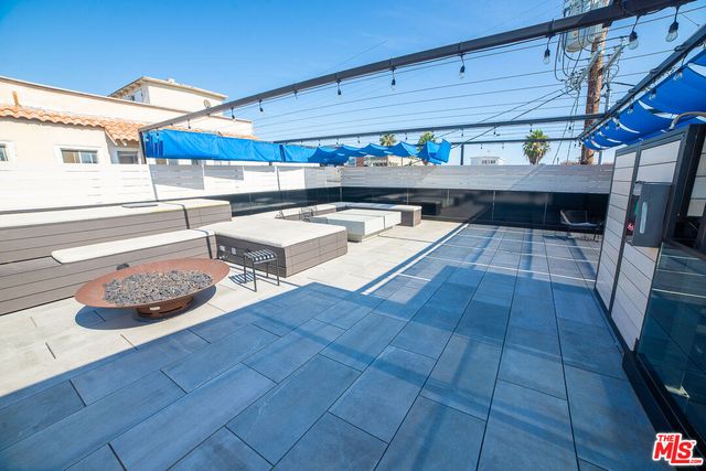 a view of a patio with dining table and chairs under an umbrella