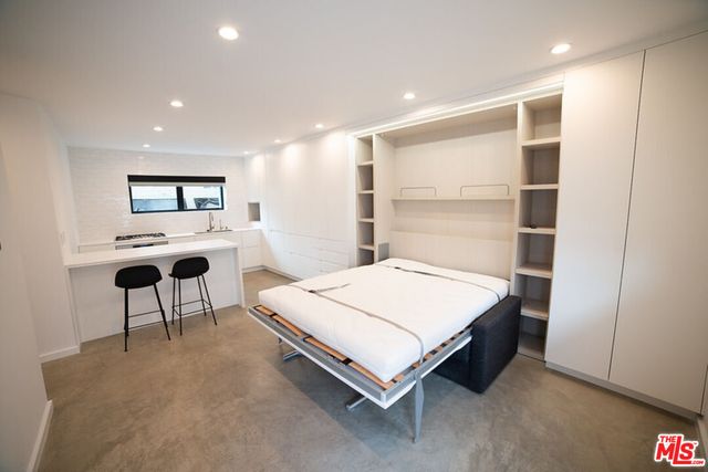 a kitchen with stainless steel appliances a table and chairs in it