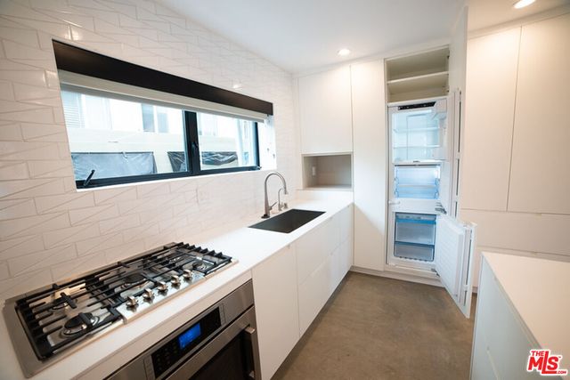 a kitchen with stainless steel appliances granite countertop a stove and a refrigerator
