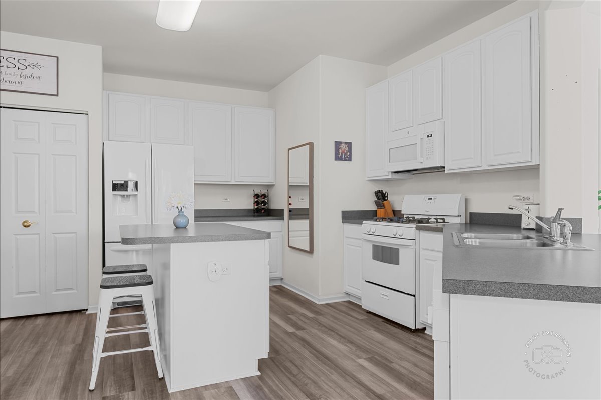 263 Lillian Court Geneva, IL 60134 - Photo 8 of 27 a kitchen with white cabinets and white appliances