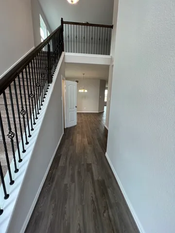 a view of a hallway with wooden floor and staircase