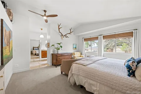 a spacious bedroom with a large bed and a chandelier