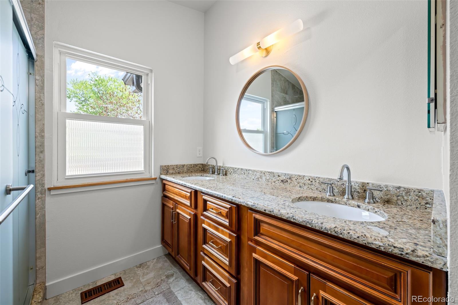 755 Old Stone Drive Highlands Ranch, CO 80126 - Photo 25 of 44 a bathroom with a granite countertop sink a mirror and a window