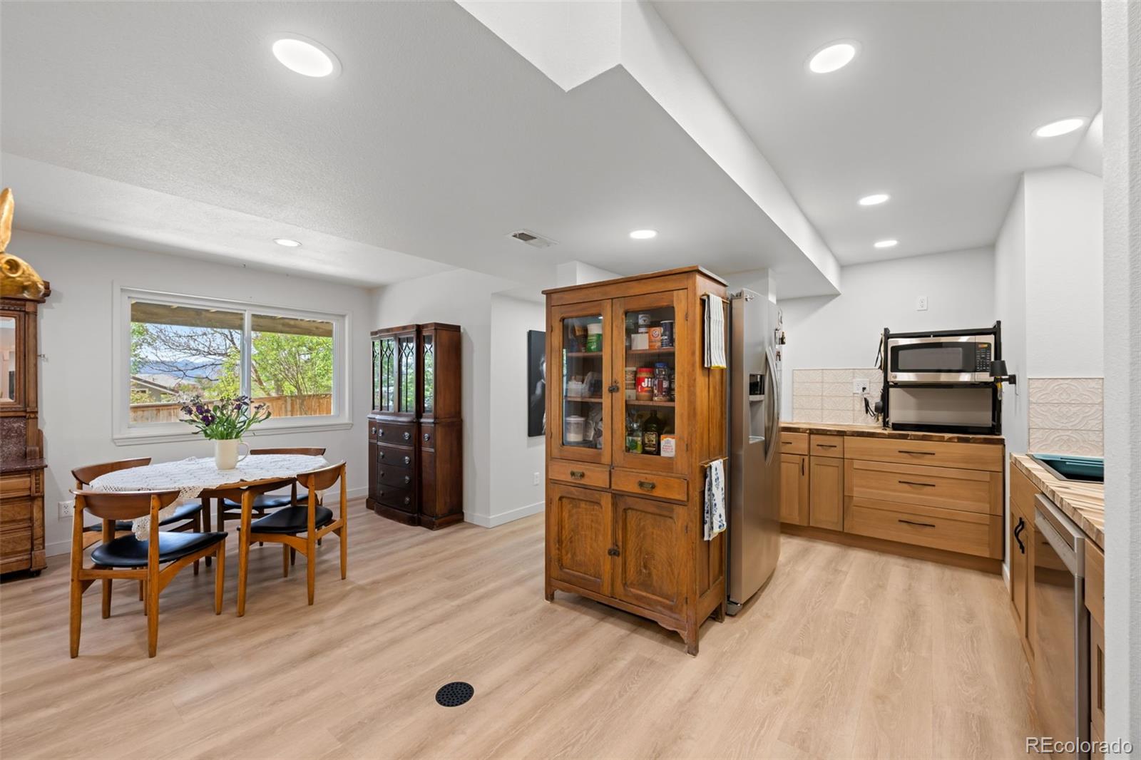 755 Old Stone Drive Highlands Ranch, CO 80126 - Photo 33 of 44 a kitchen with stainless steel appliances kitchen island granite countertop a refrigerator oven stove a dining table and chairs with wooden floor