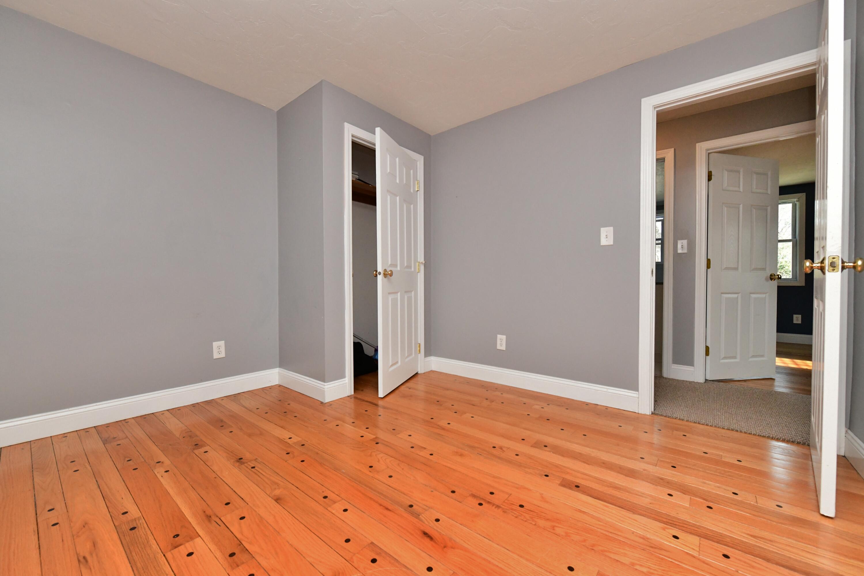 65 Siasconset Drive Sagamore Beach, MA 02562 - Photo 27 of 53 a view of an empty room with wooden floor and a bathroom