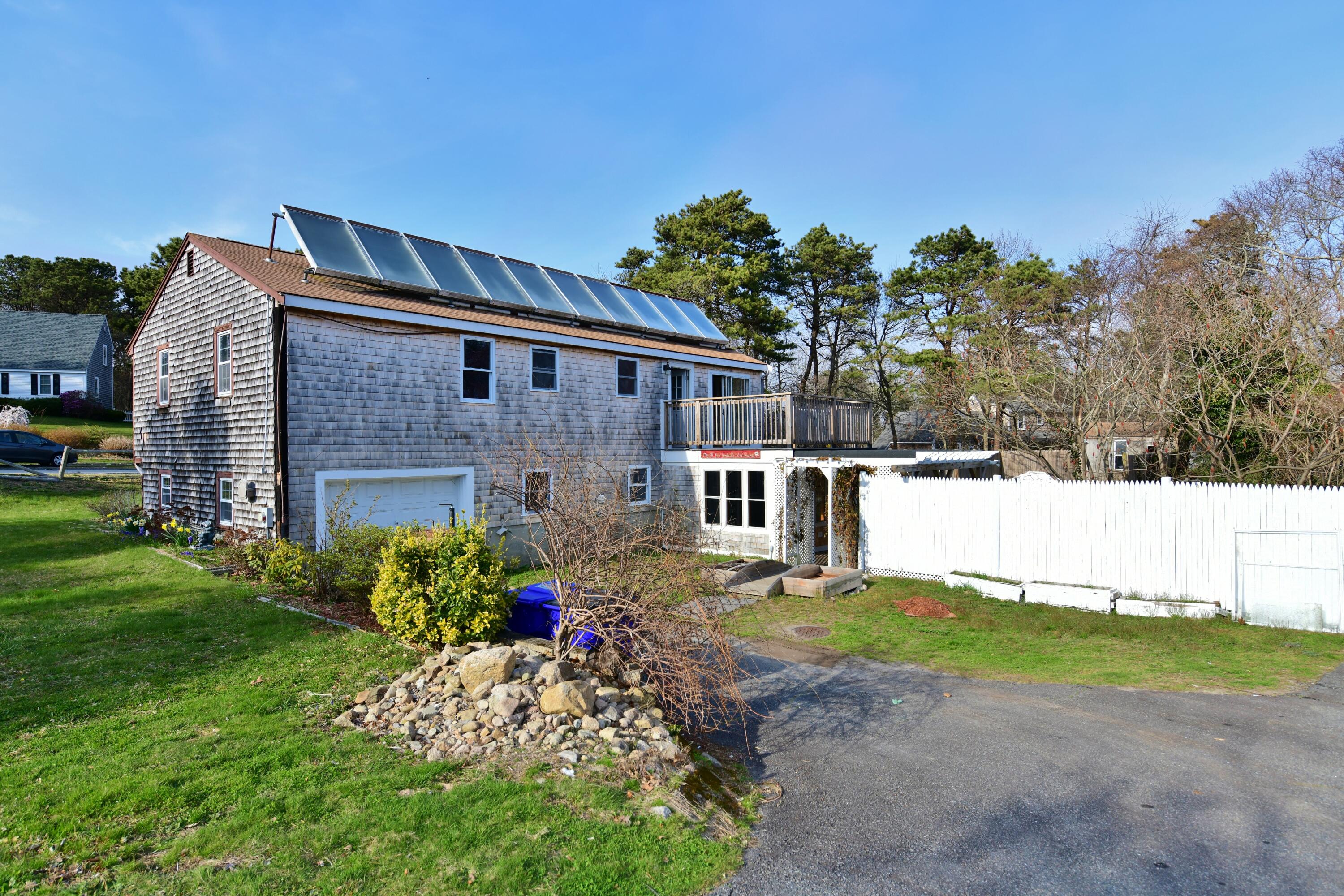 65 Siasconset Drive Sagamore Beach, MA 02562 - Photo 38 of 53 a front view of a house with a yard and a garden