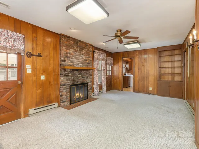 a view of an empty room with a fireplace and a window