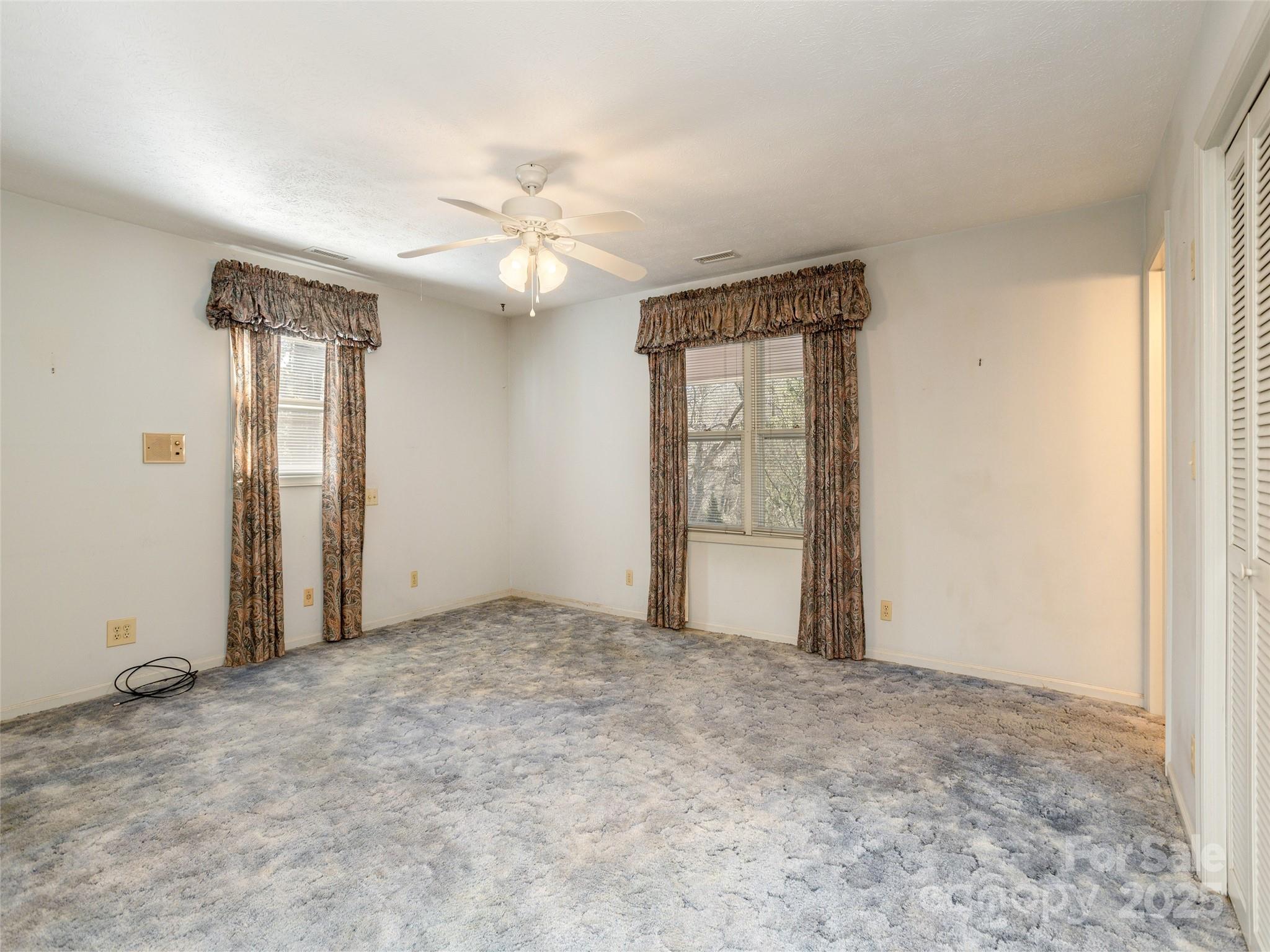 2640 Haywood Road Hendersonville, NC 28791 - Photo 19 of 41 an empty room with windows and fan