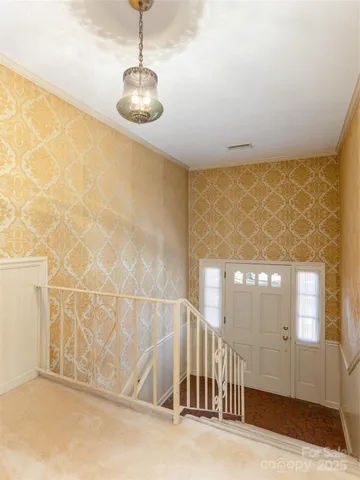 a view of a livingroom with wooden floor and a chandelier