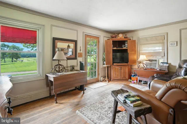 a living room with furniture wooden floor and a large window