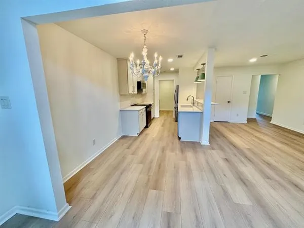 a room with wooden floor and cabinets