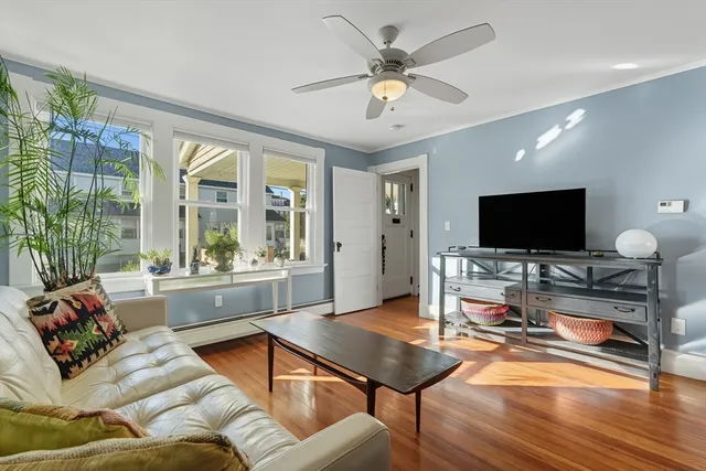 a living room with furniture a flat screen tv and a large window