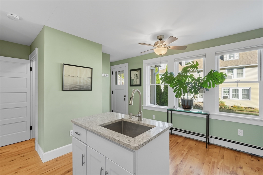 5 Grant Street, Unit 5 Easthampton, MA 01027 - Photo 15 of 36 a kitchen with granite countertop a sink and a stove with wooden floor