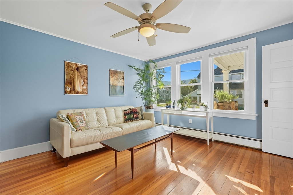 5 Grant Street, Unit 5 Easthampton, MA 01027 - Photo 9 of 36 a living room with furniture and a large window with wooden floor