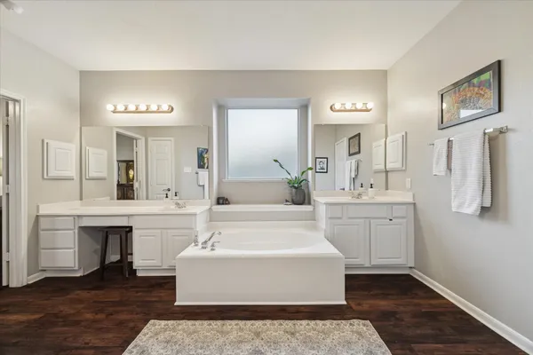 a spacious bathroom with a double vanity sink a mirror and a bathtub