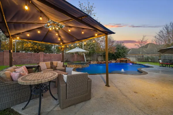 a patio with a table and chairs under an umbrella