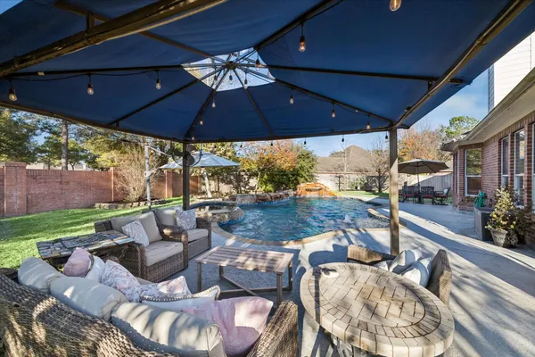 a view of a patio with couches chairs under an umbrella