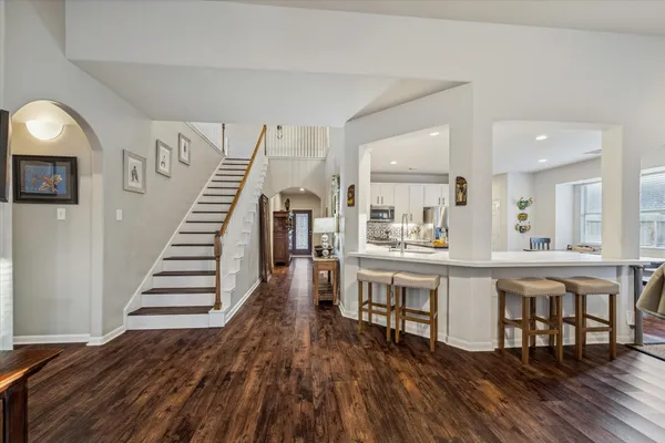 a kitchen with white cabinets and wooden floor