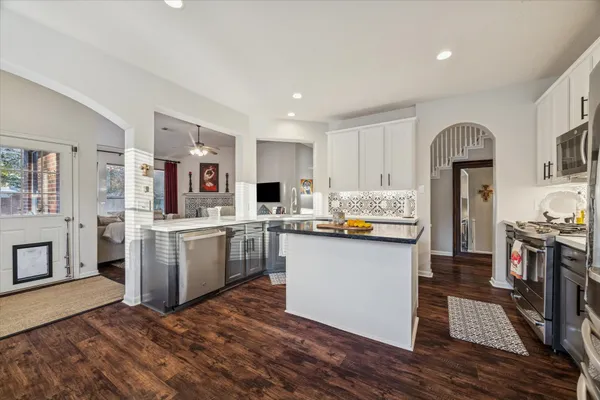 a kitchen with cabinets and wooden floor