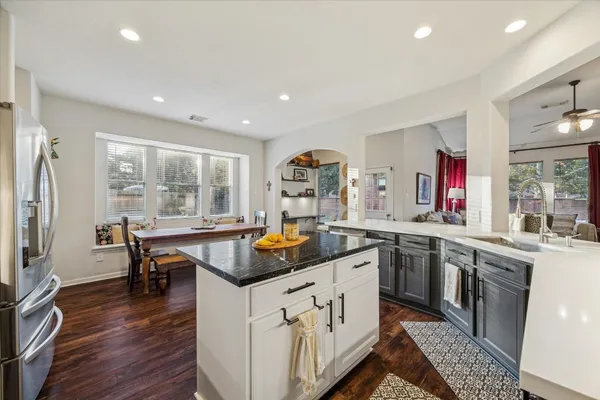 a kitchen with stainless steel appliances granite countertop sink stove top oven and cabinets