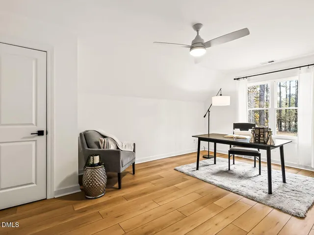 a view of a workspace with furniture and a window