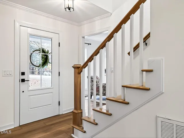 a view of front door with wooden floor and mirror