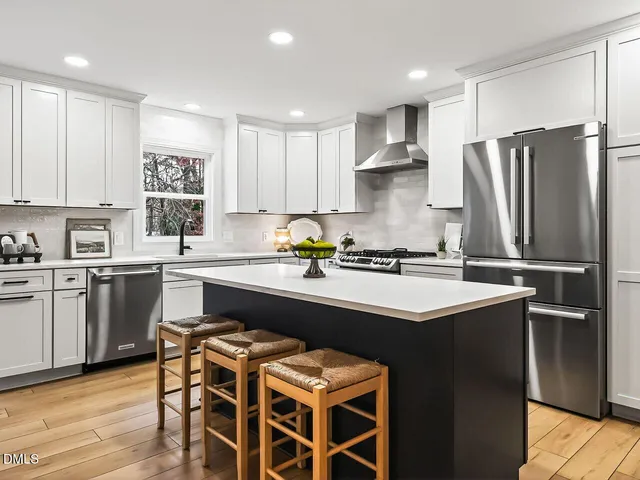a kitchen with a sink stainless steel appliances and white cabinets