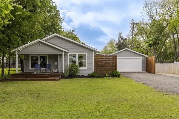 a front view of a house with a yard and trees