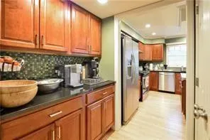 a kitchen with stainless steel appliances granite countertop a refrigerator and a stove top oven
