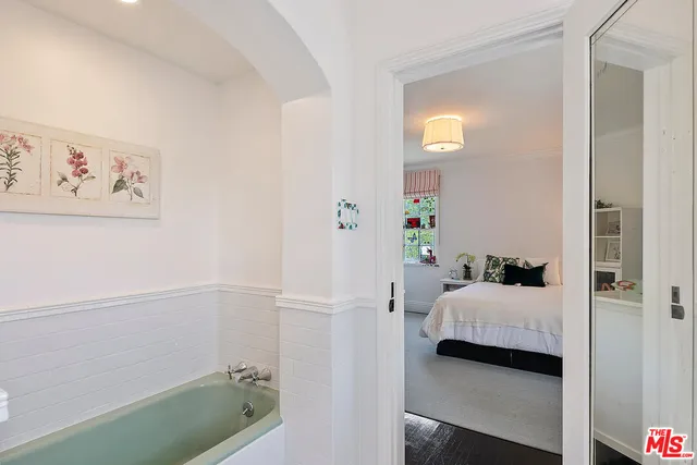 a bedroom with a large bed and a chandelier