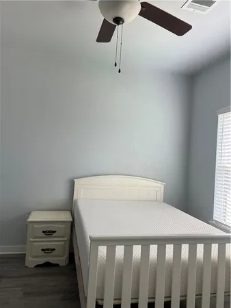 a bedroom with a bed a table and a chandelier