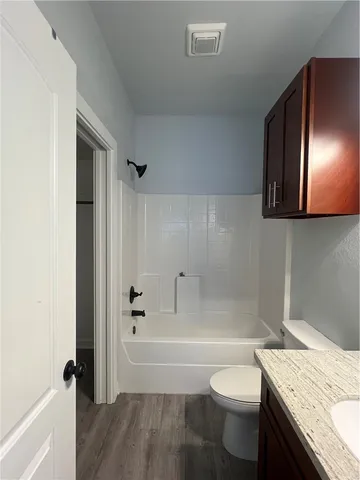 a bathroom with a granite countertop toilet a sink and bathtub