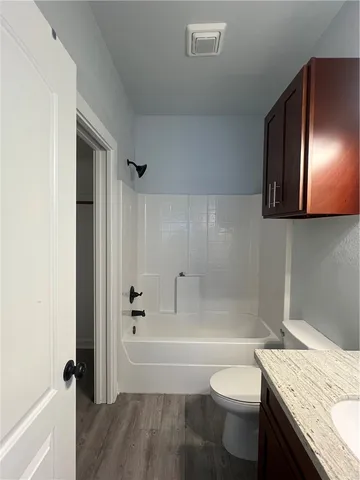a bathroom with a granite countertop toilet a sink and bathtub