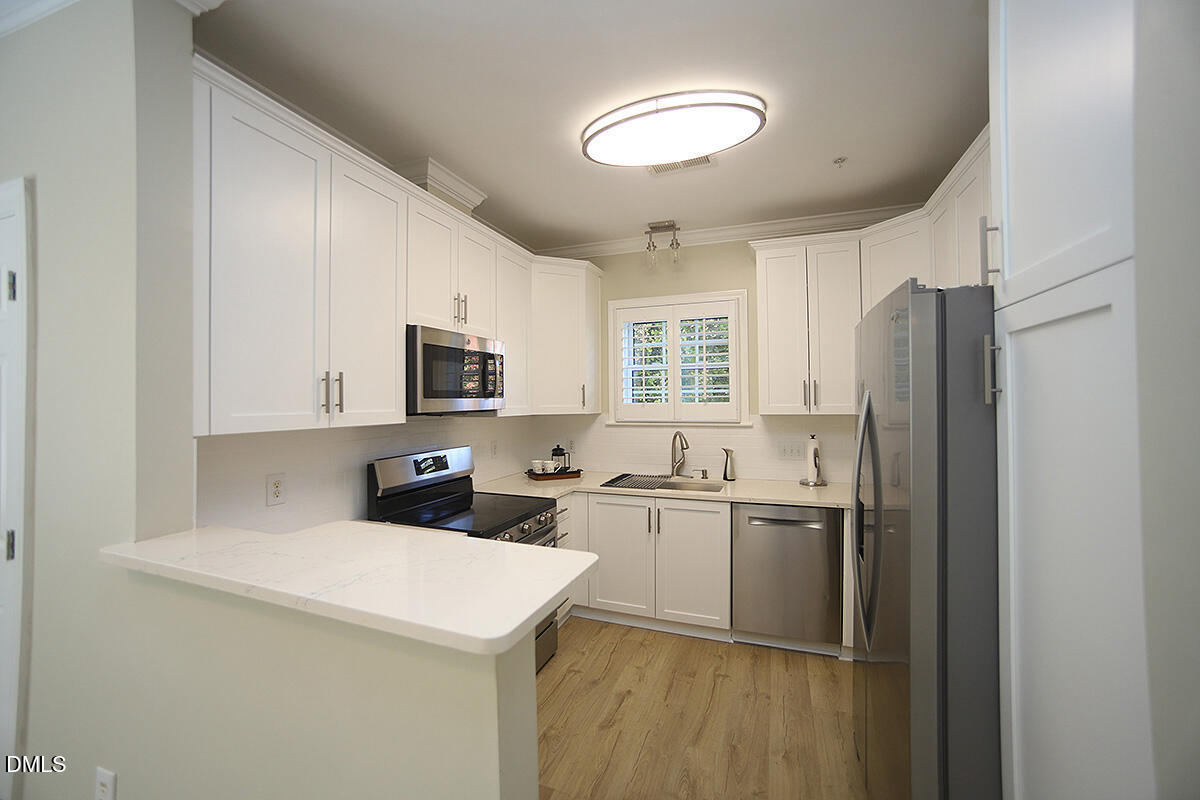 100 Northbrook Drive, Unit 207 Raleigh, NC 27609 - Photo 14 of 39 a kitchen with a sink a refrigerator and cabinets