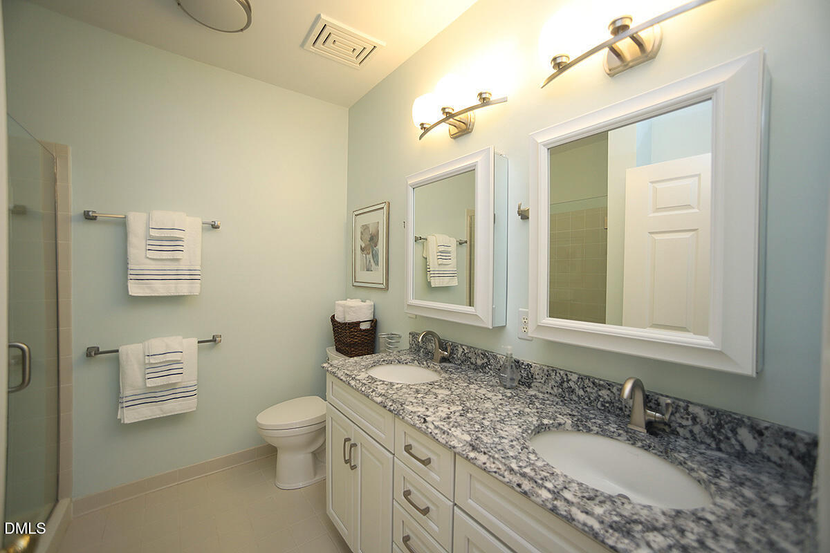 100 Northbrook Drive, Unit 207 Raleigh, NC 27609 - Photo 24 of 39 a bathroom with a granite countertop sink a toilet and a mirror