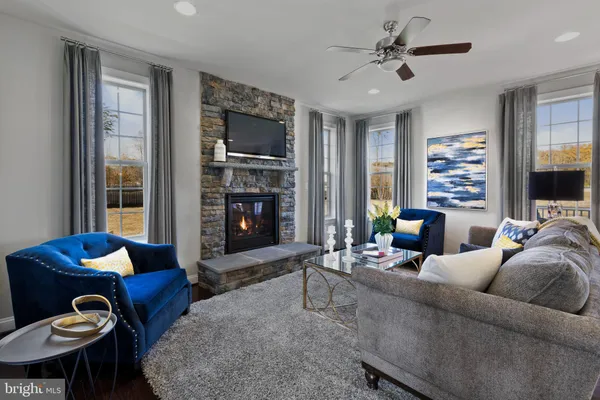 a living room with furniture a flat screen tv and a window