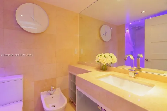 a bathroom with a sink vanity mirror and toilet